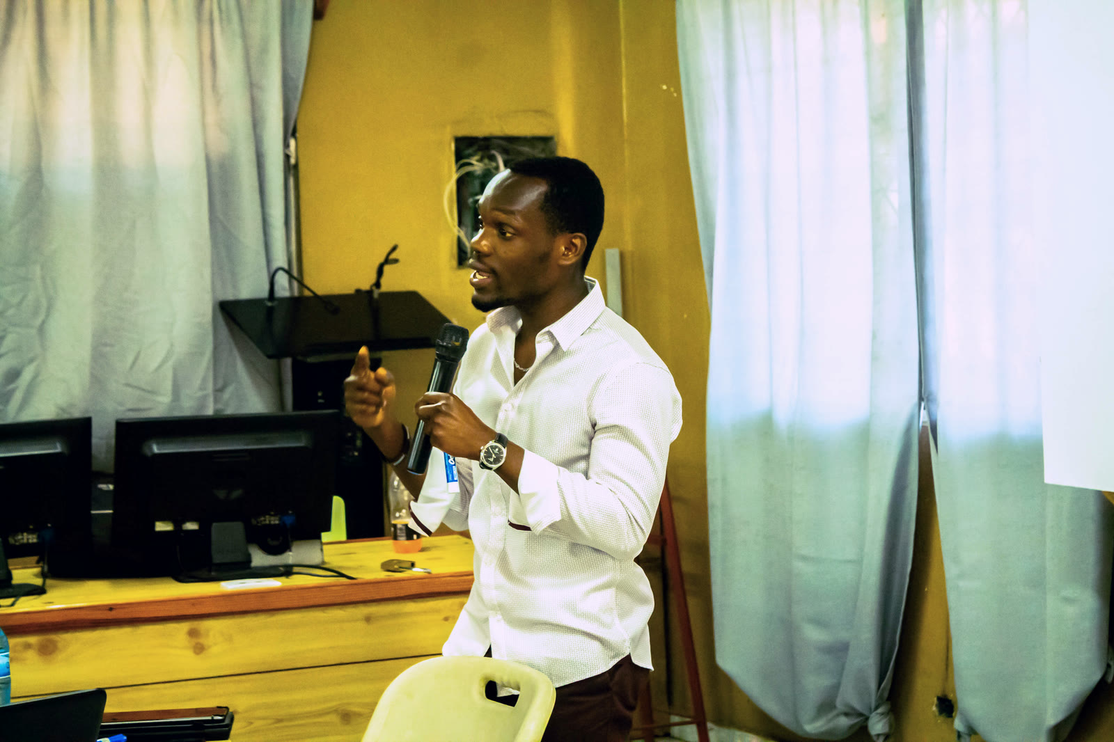 Anderson Vil speaking into a handheld microphone during a teaching or presentation session.